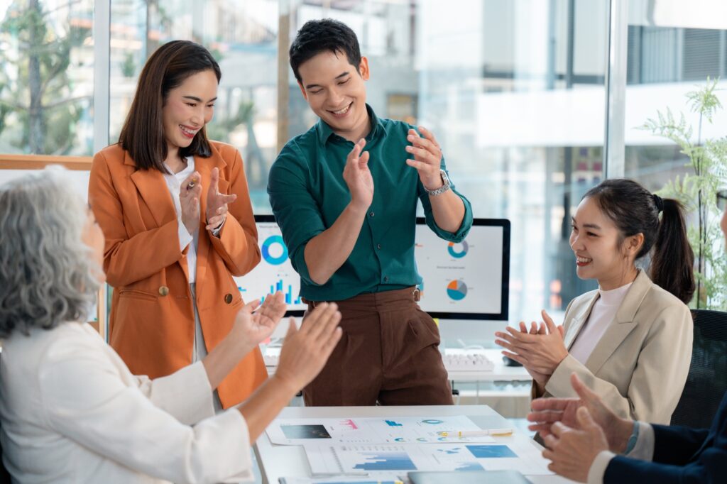 Group of asian businesspeople clapping hands during a meeting in the office